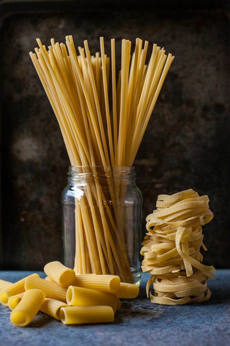 Spaghetti seco y tagliatelle fresco sobre la mesa de trabajo